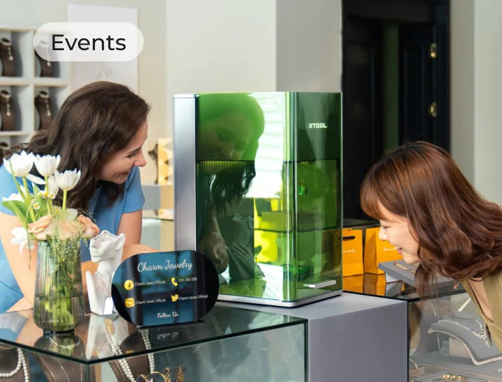 Two women interacting with the futuristic laser engraver F1 Ultra.